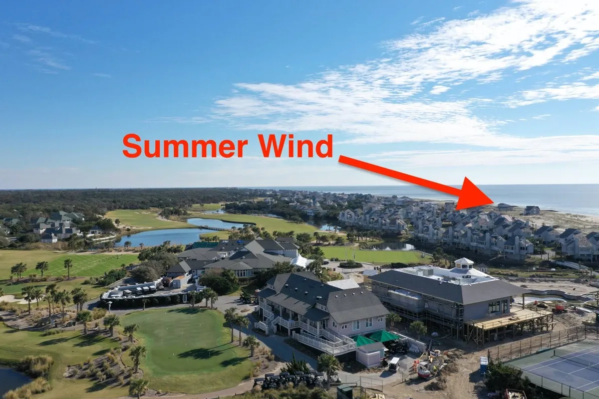 A beautiful sweeping view over the golf course, beach, and water, with homes nestled along the coastline. The scene captures the island’s recreational amenities and the allure of golfing with a dramatic ocean backdrop, complemented by the warm glow of the sunset.